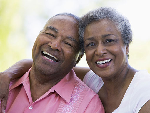 elderly couple hugging and smiling